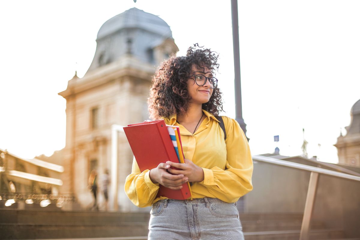 lady outside university holding book