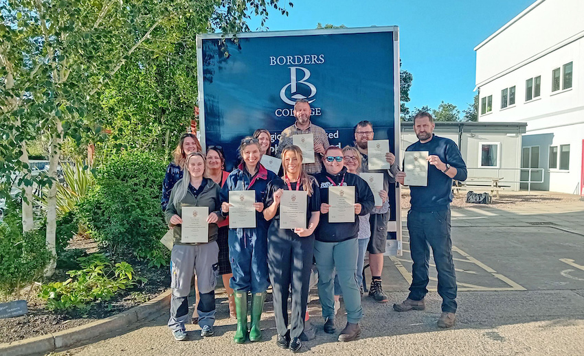 Group of staff standing with certificates in hand.