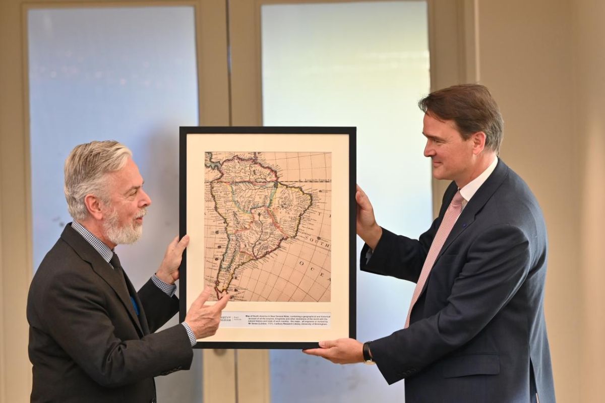 two people holding a framed picture of a map