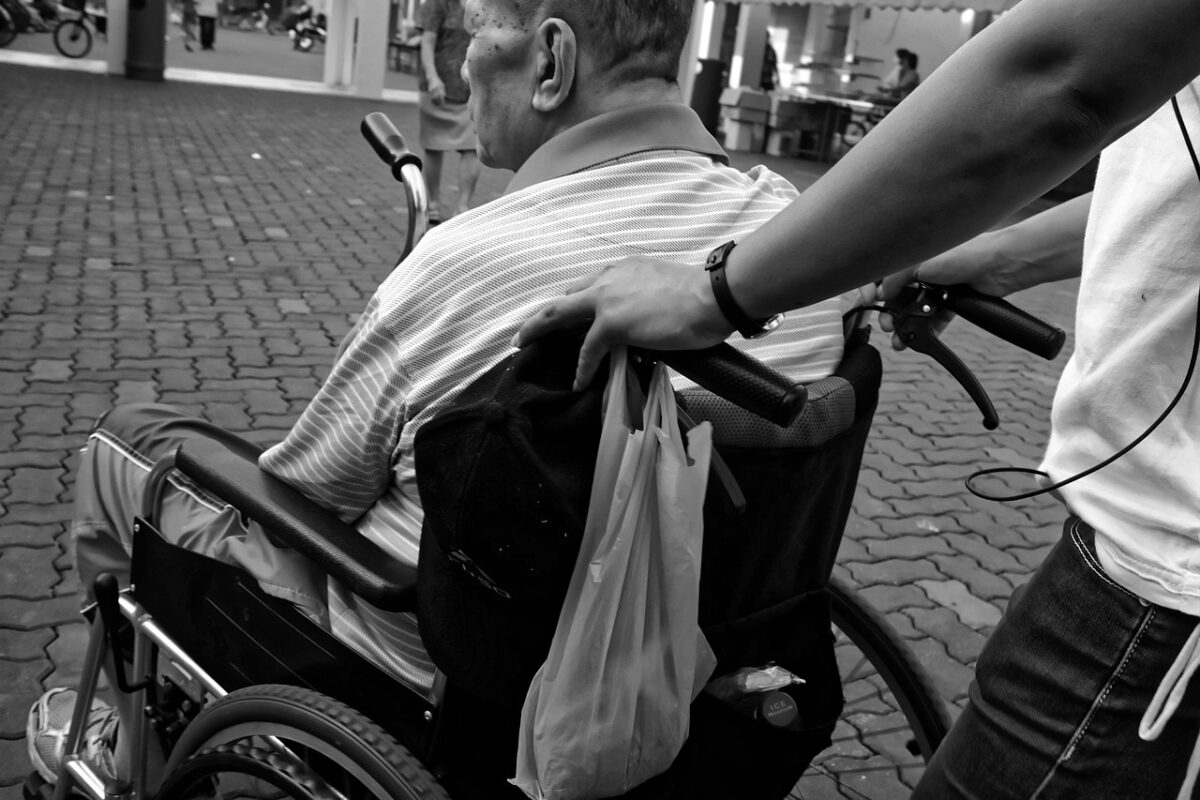 Young carer helping someone in a wheelchair