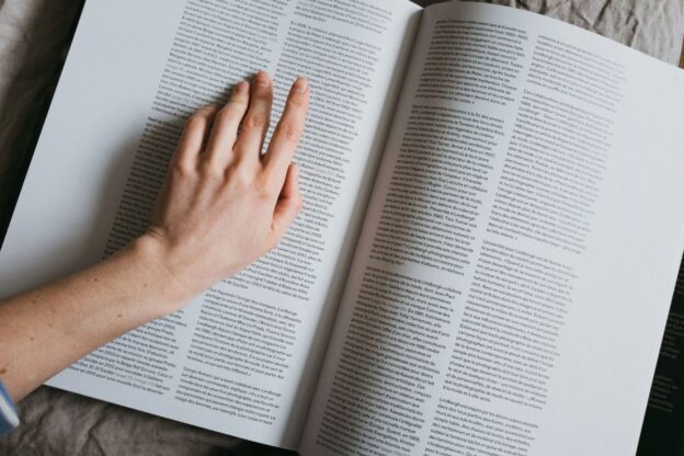 finger pointing at words in large book