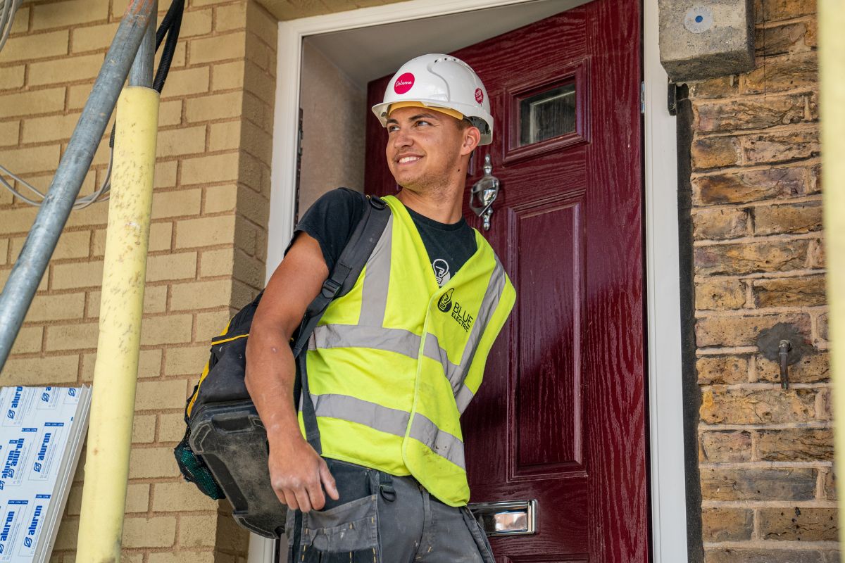 man in high vis jacket entering house
