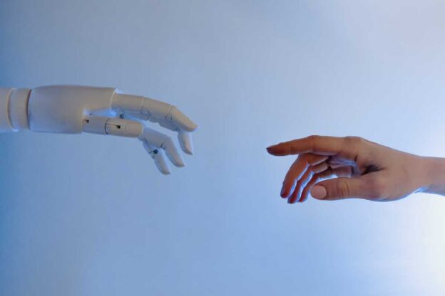 Human hand reaching out to AI hand