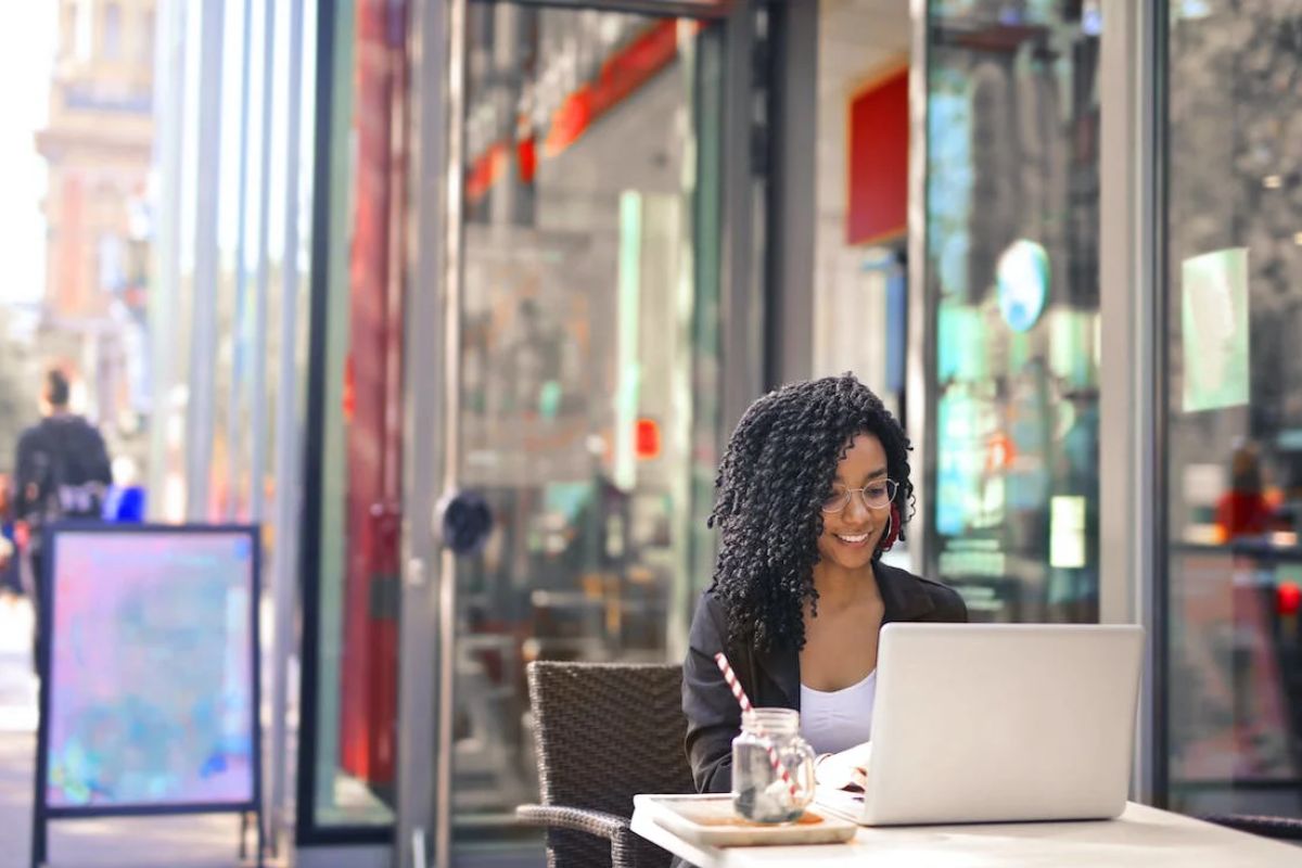 woman working on laptop outside cafe