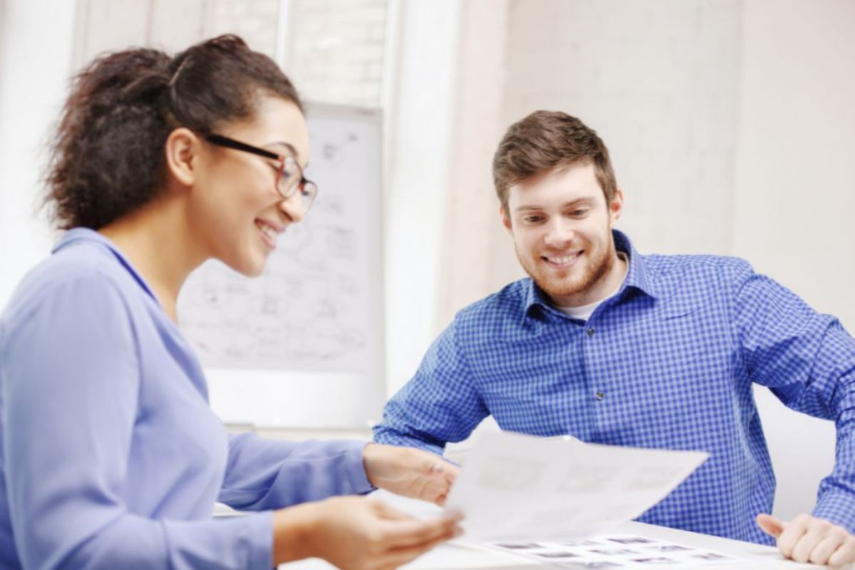 man and woman in blue shirts looking at paper