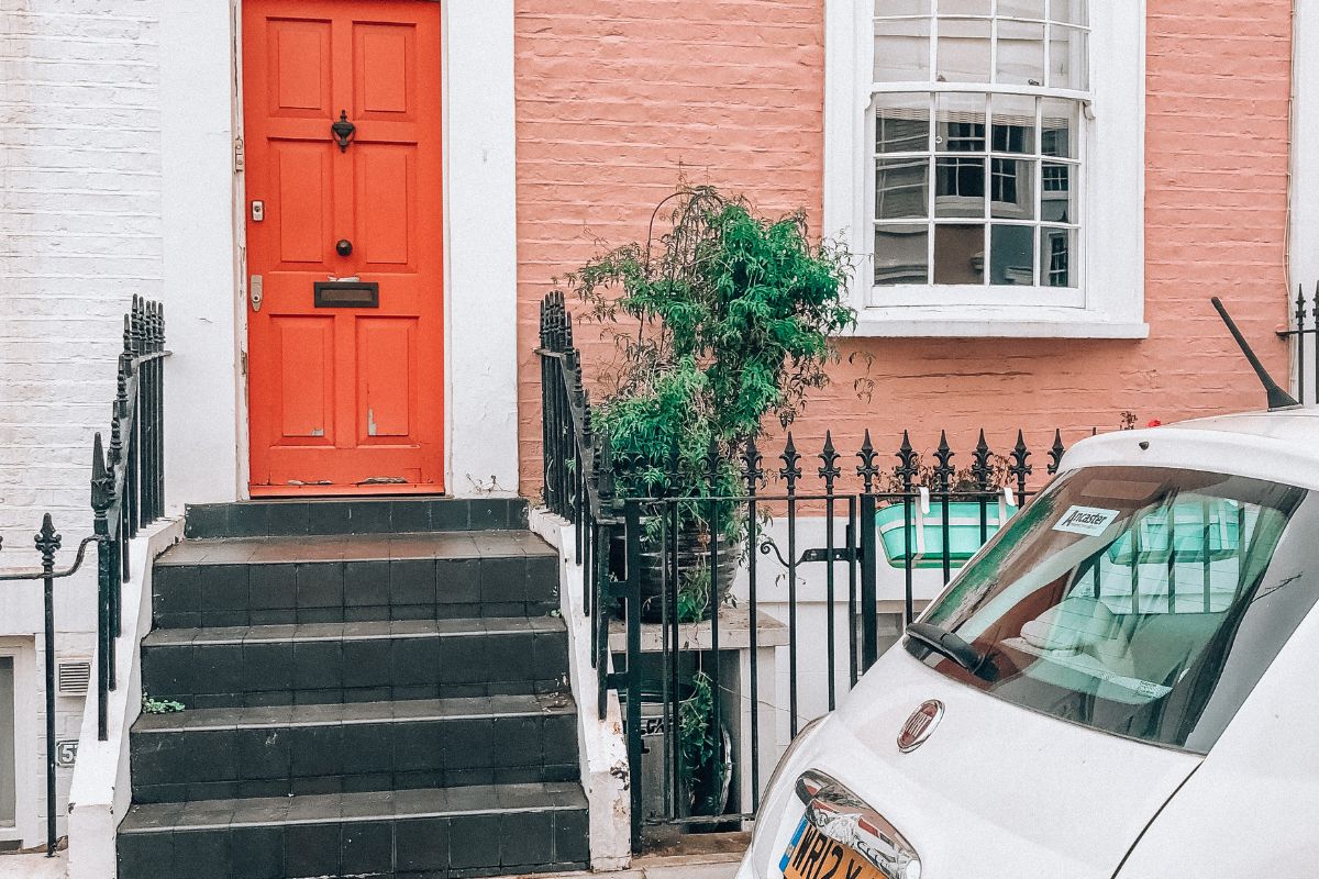 orange townhouse with white car outside