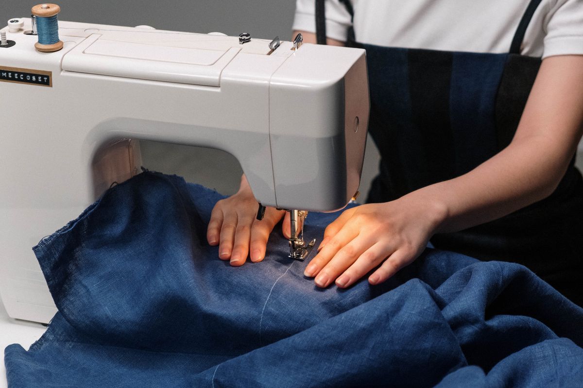person sewing on sewing machine