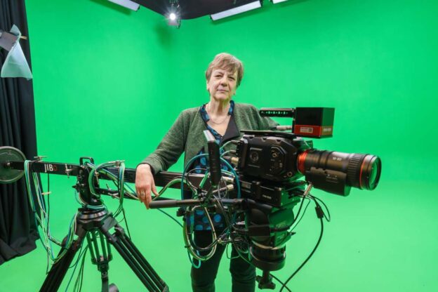 Professor Arabella Plouviez standing with a camera in a green screen studio