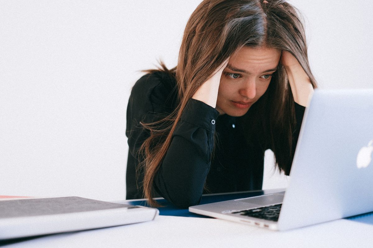 student stressed while looking at a laptop