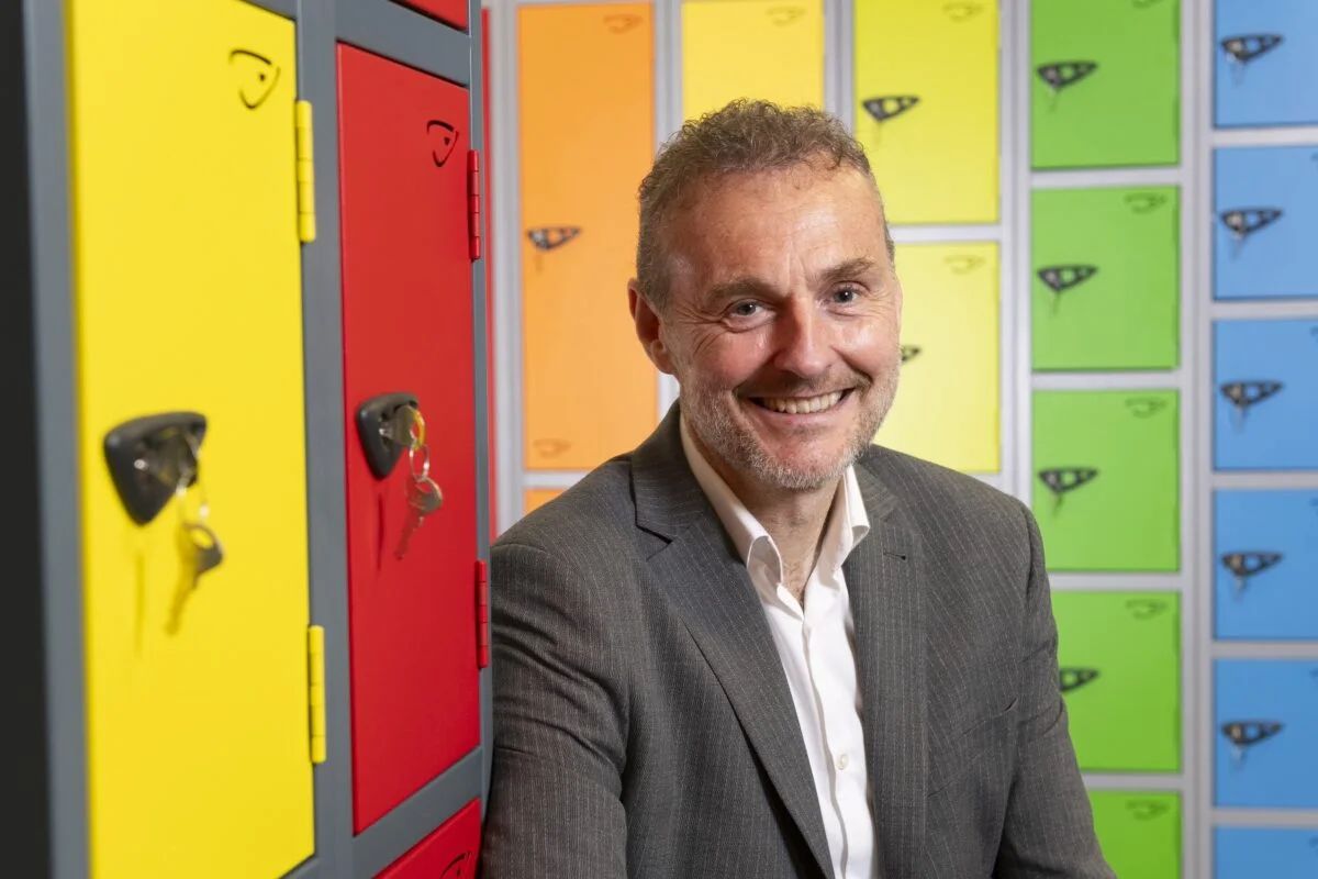 guy stood next to colorful lockers