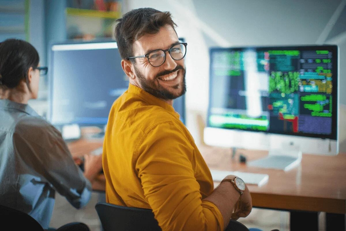 Man smiling looking away from a screen