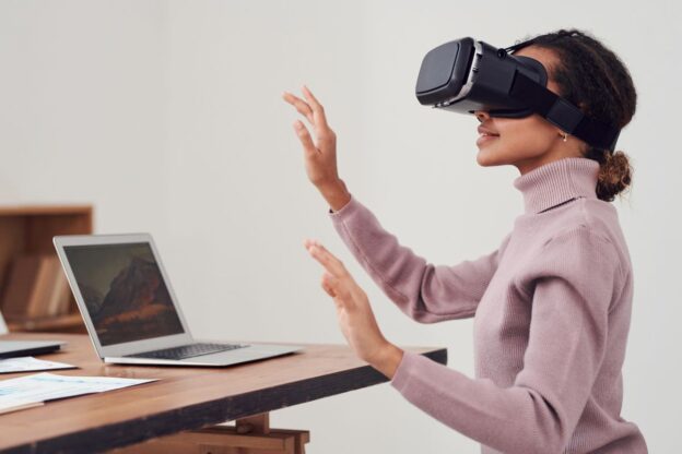 Lady in VR Headset next to laptop