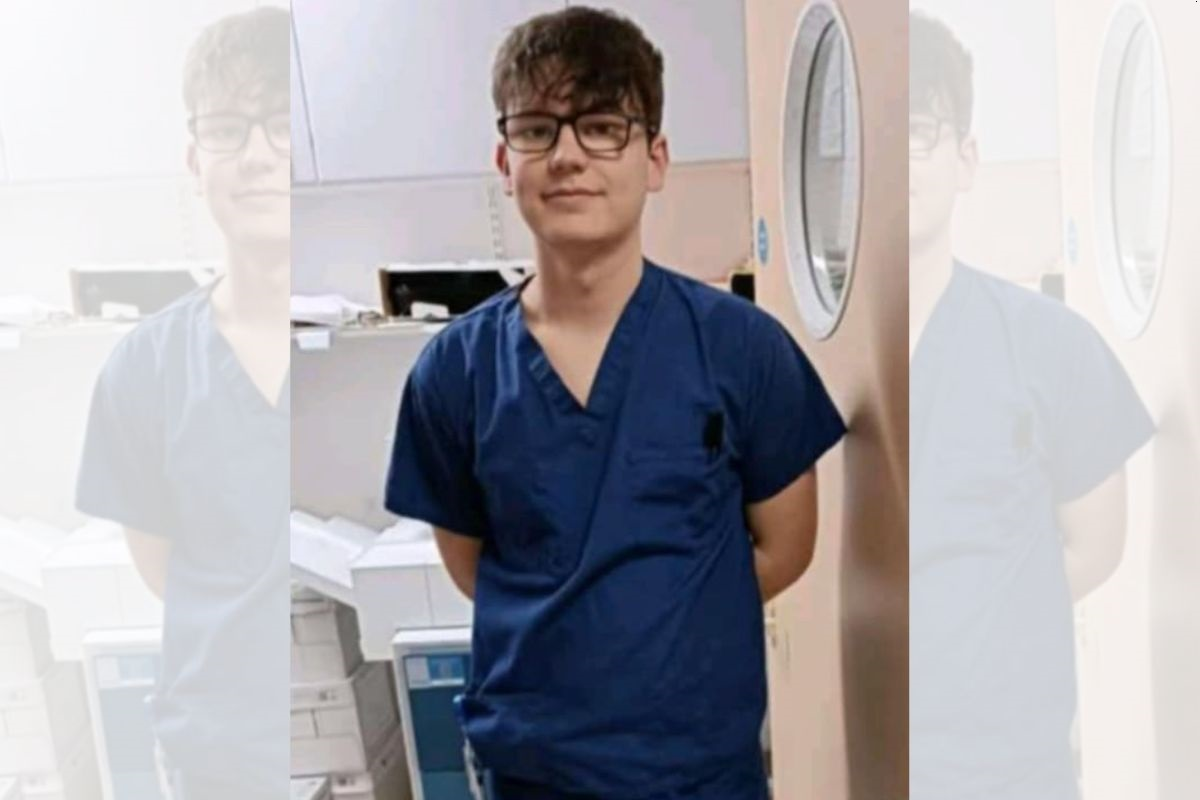 Portrait photo of Charlie Sinclair in nursing uniform, looking at the camera.