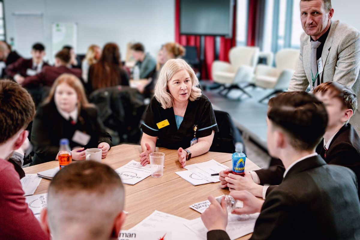 A group of students at a workshop with nursing staff