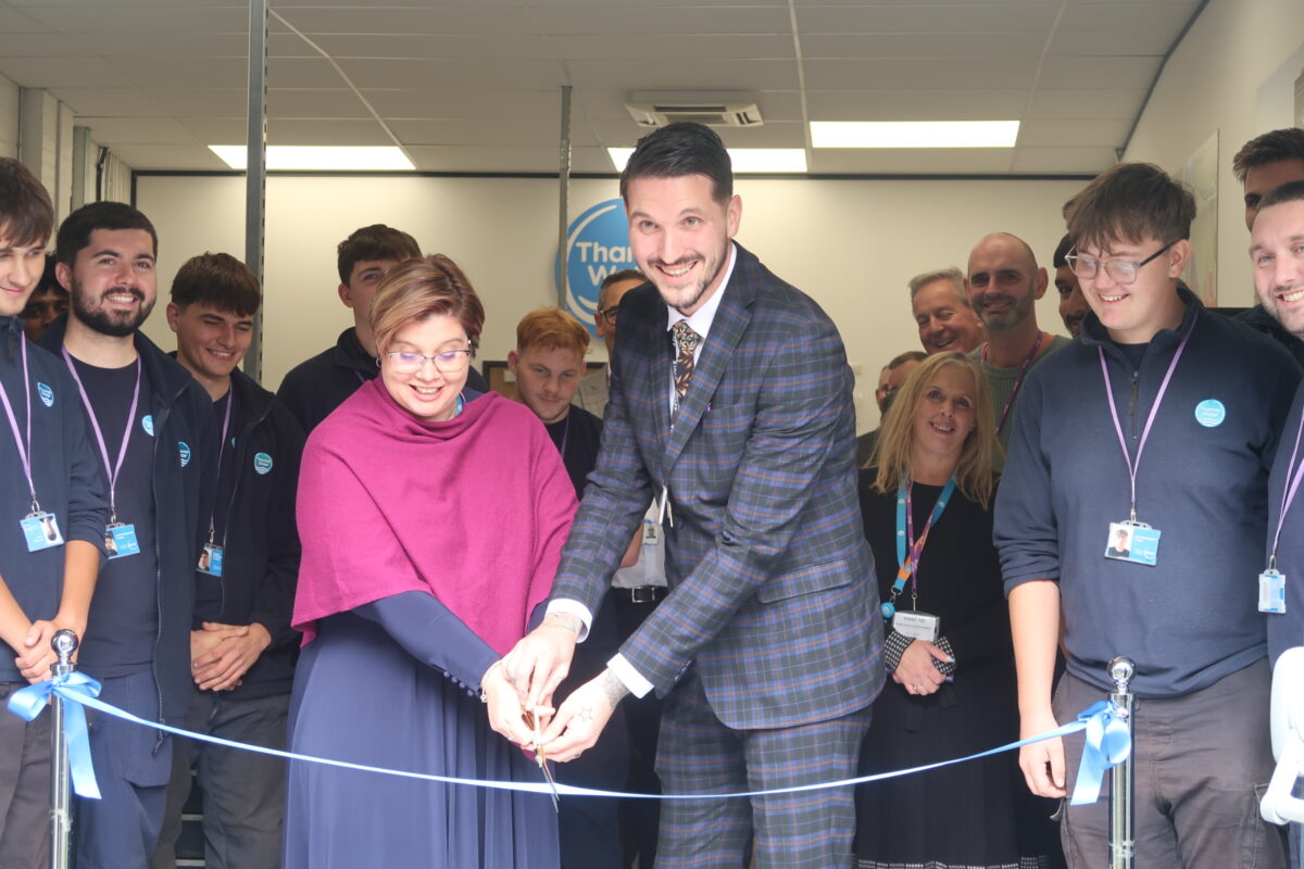 Man and women cut ribbon, opening a new training centre.