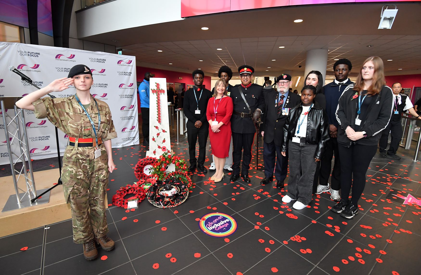 Sandwell College student in army uniform salutes next to the college principal, deputy lieutenant, war veteran and students