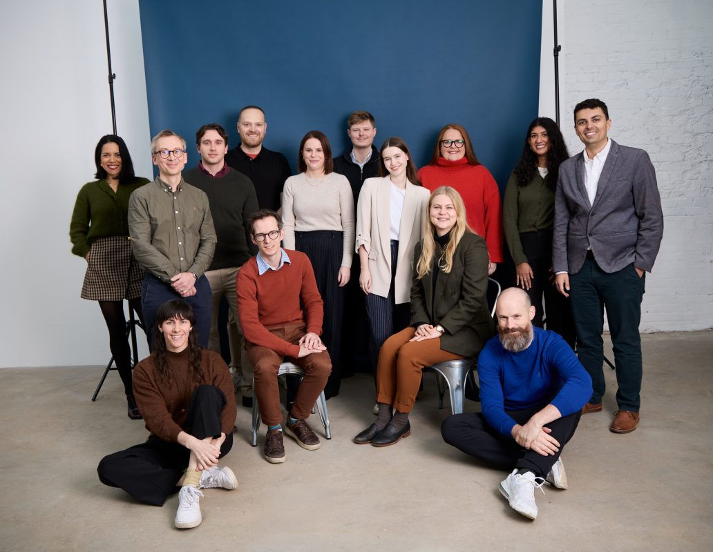 Avencera's team members gather in front of a backdrop in a photo studio.