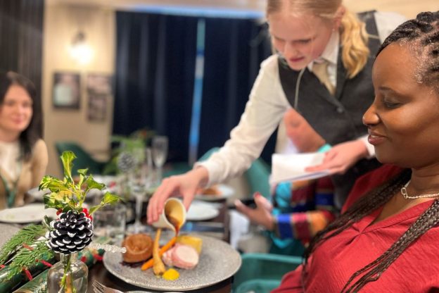 a student serves food in a college restaurant