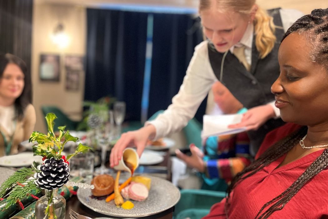 a student serves food in a college restaurant