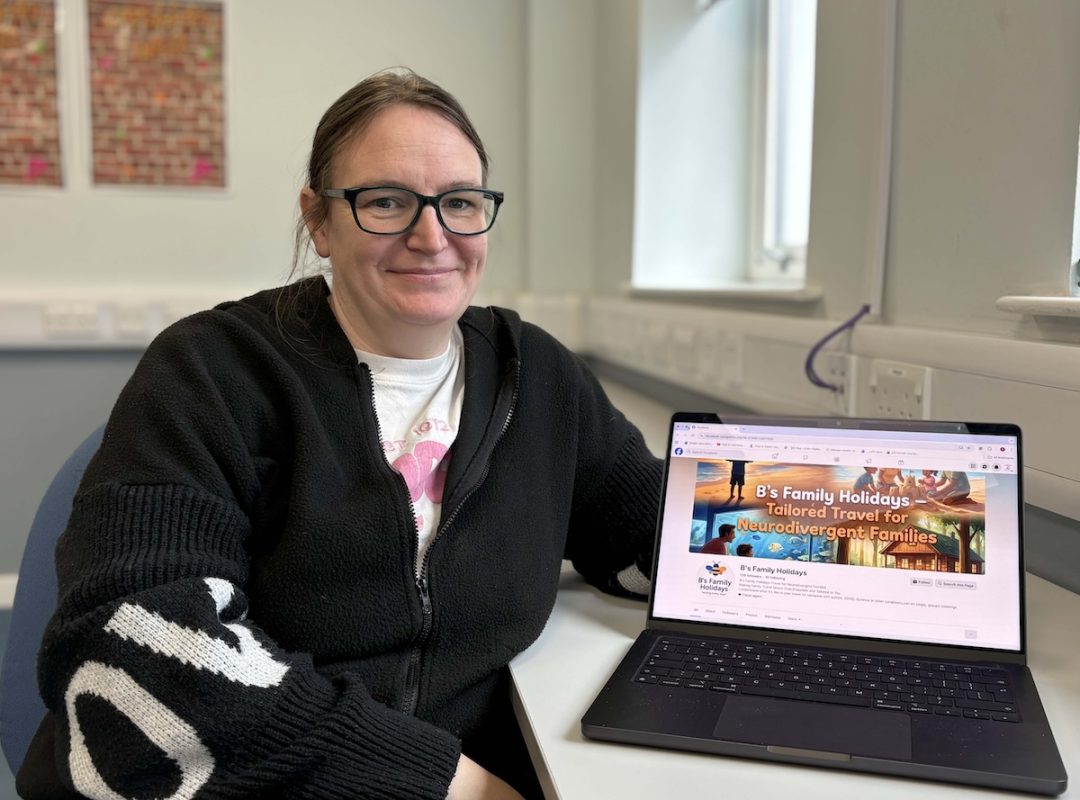 Photo of Bernadette Oliver sitting in a classroom setting with a laptop alongside