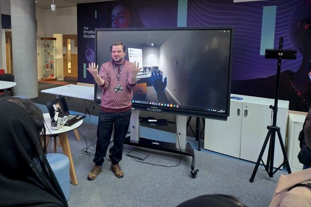 Clark Mitton, the Digital Experience Design Lead at Bradford College, uses VR software to model his hands on the large screen behind him.