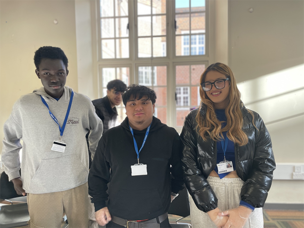 ESOL students Chayma Azouzi, left, Anthony Pacubas, and Abdou Baye Dia at the fundraising sale for Refugees At Home