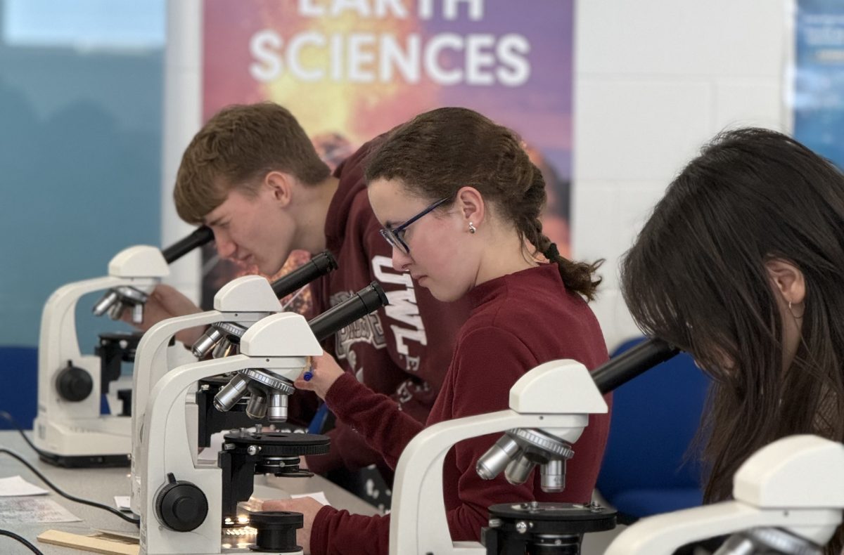 students look through microscopes at a university of derby experience day