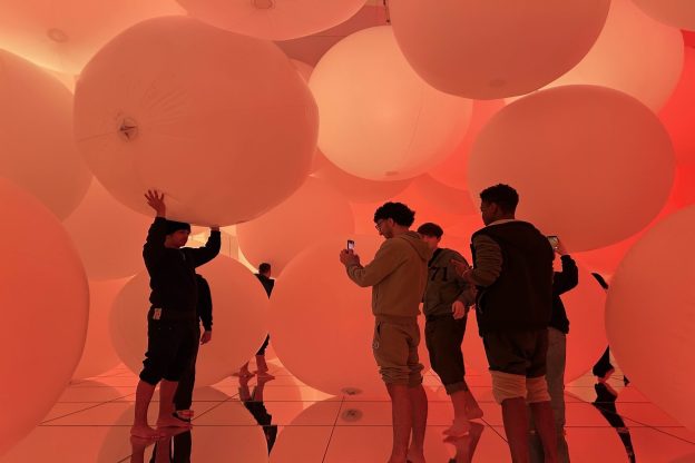 The Sheffield College students moving in an interactive space in Japan filled with spheres of light.