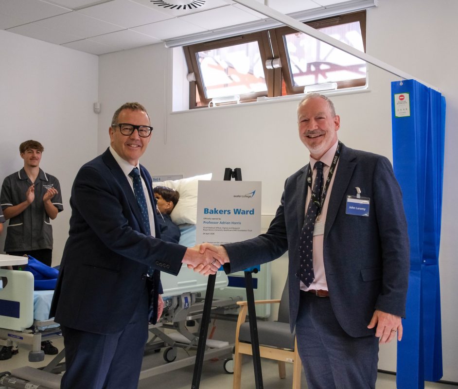 Two people shake hands infront of a plaque unveiling in Exeter College's hospital training ward.