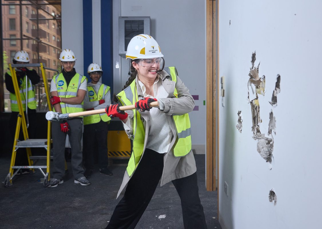 Student Beheshta “Breaking the Wall” of the new College of North West London campus on