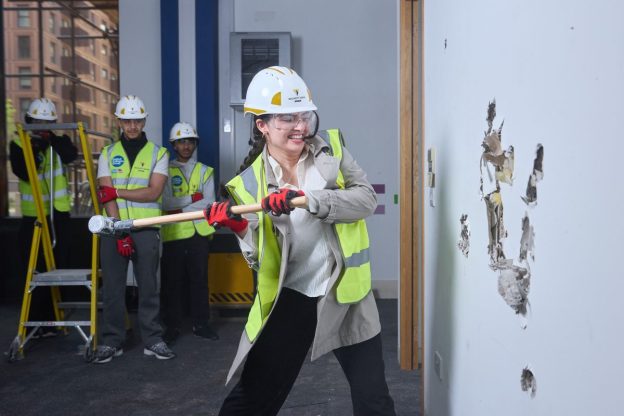 Student Beheshta “Breaking the Wall” of the new College of North West London campus on