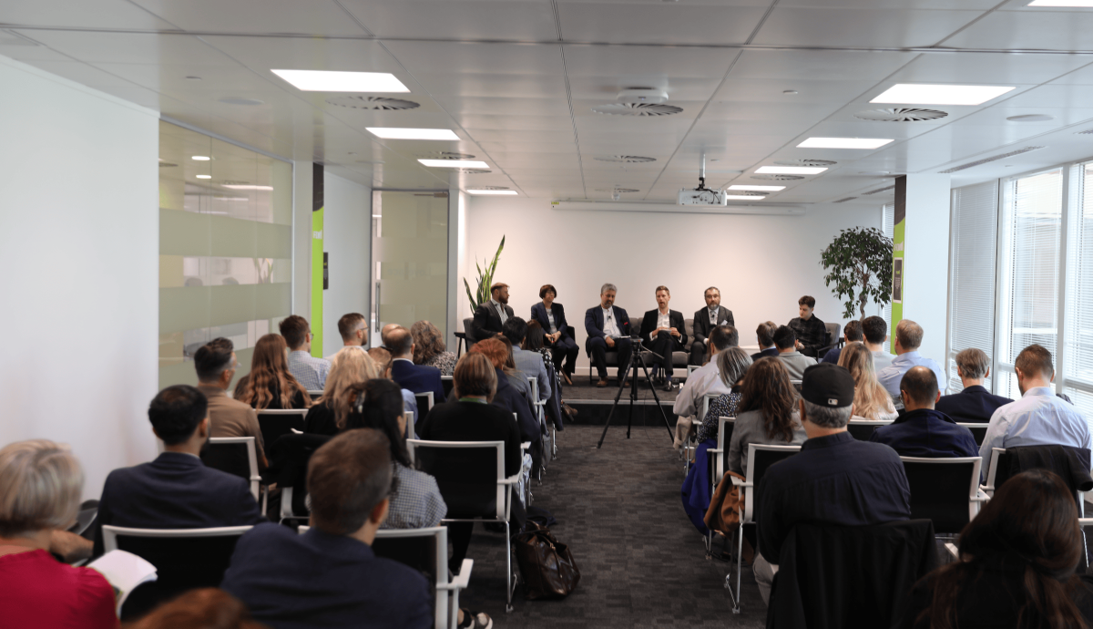 People in a room watching a talk at the techUK event