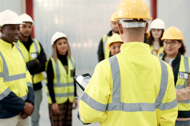 Construction, teamwork and people in meeting for planning, brainstorming and discussion in building. Architecture, engineering and men and women for inspection, property development and project