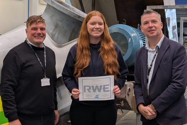 Jessica standing in between Luke and Paul holding her certificate