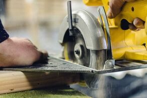 Person using circular saw to cut a peice of wood