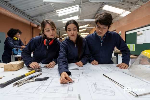 3 students reading schematics