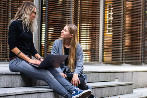 student and tutor sat next to each other on stairs