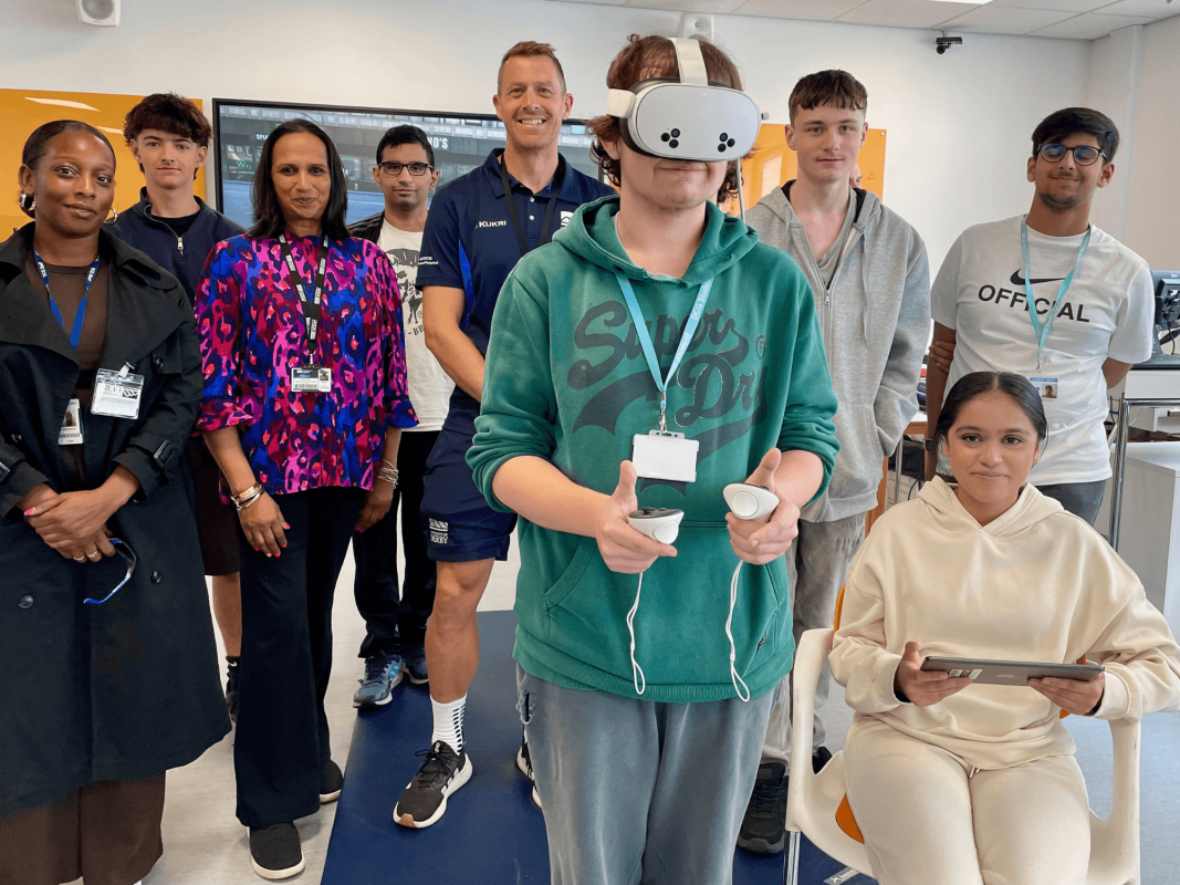 a young person is wearing a virtual headset and playing games at an event held at the University of Derby