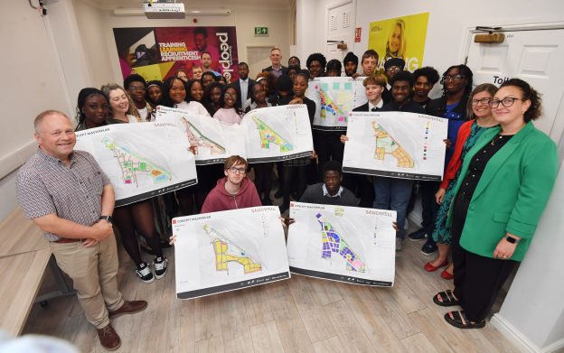 Work experience students from The Sandwell Colleges holding plans, with staff and employers