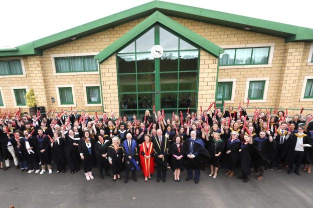 large group of Borders College graduates and staff standing outside a building