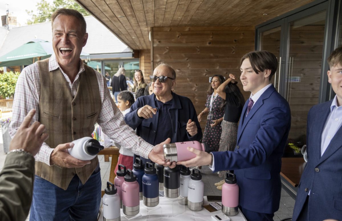 Peter Jones laughs while being handed personalised bottles for his dogs.