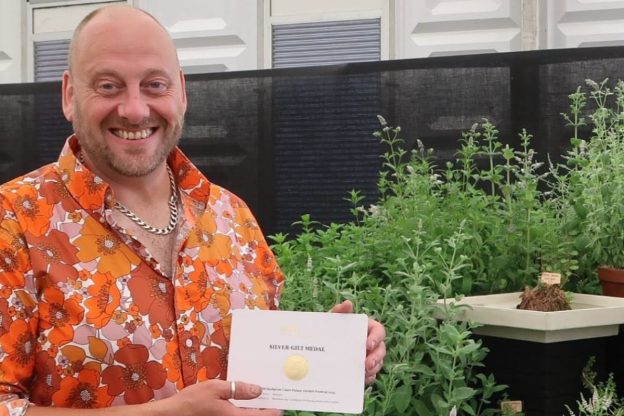 Dr Si Poole, Associate Professor of Cultural Education at the University of Chester, with a Royal Horticultural Society Silver-Gilt award. Credit - Plant Heritage.