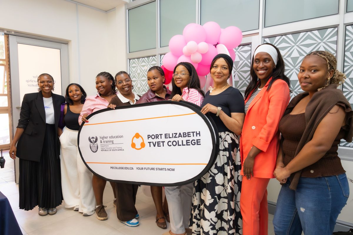 Female students at Port Elizabeth TVET College, South Africa, holding their college logo.