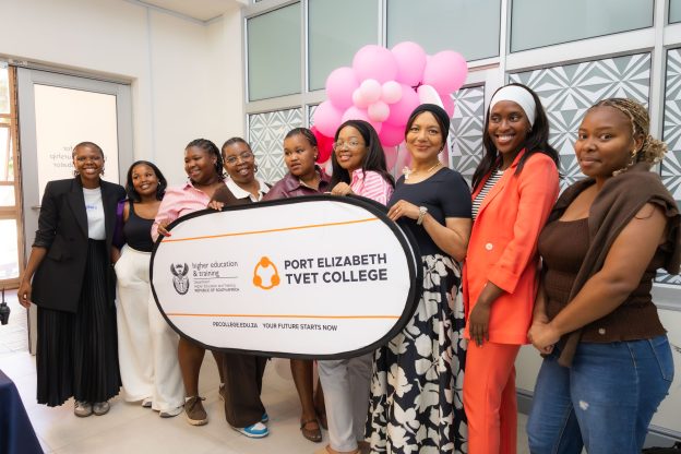 Female students at Port Elizabeth TVET College, South Africa, holding their college logo.
