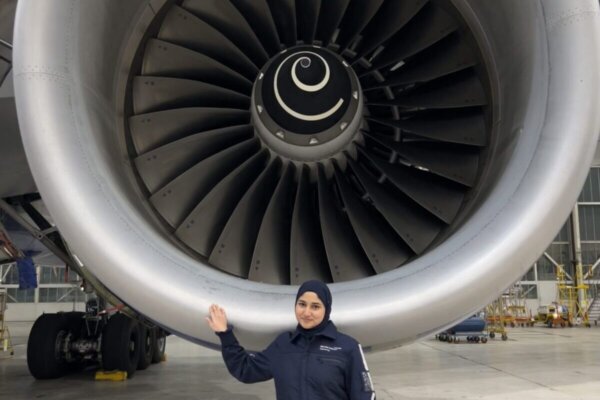 Maryam standing in front of an airplane engine